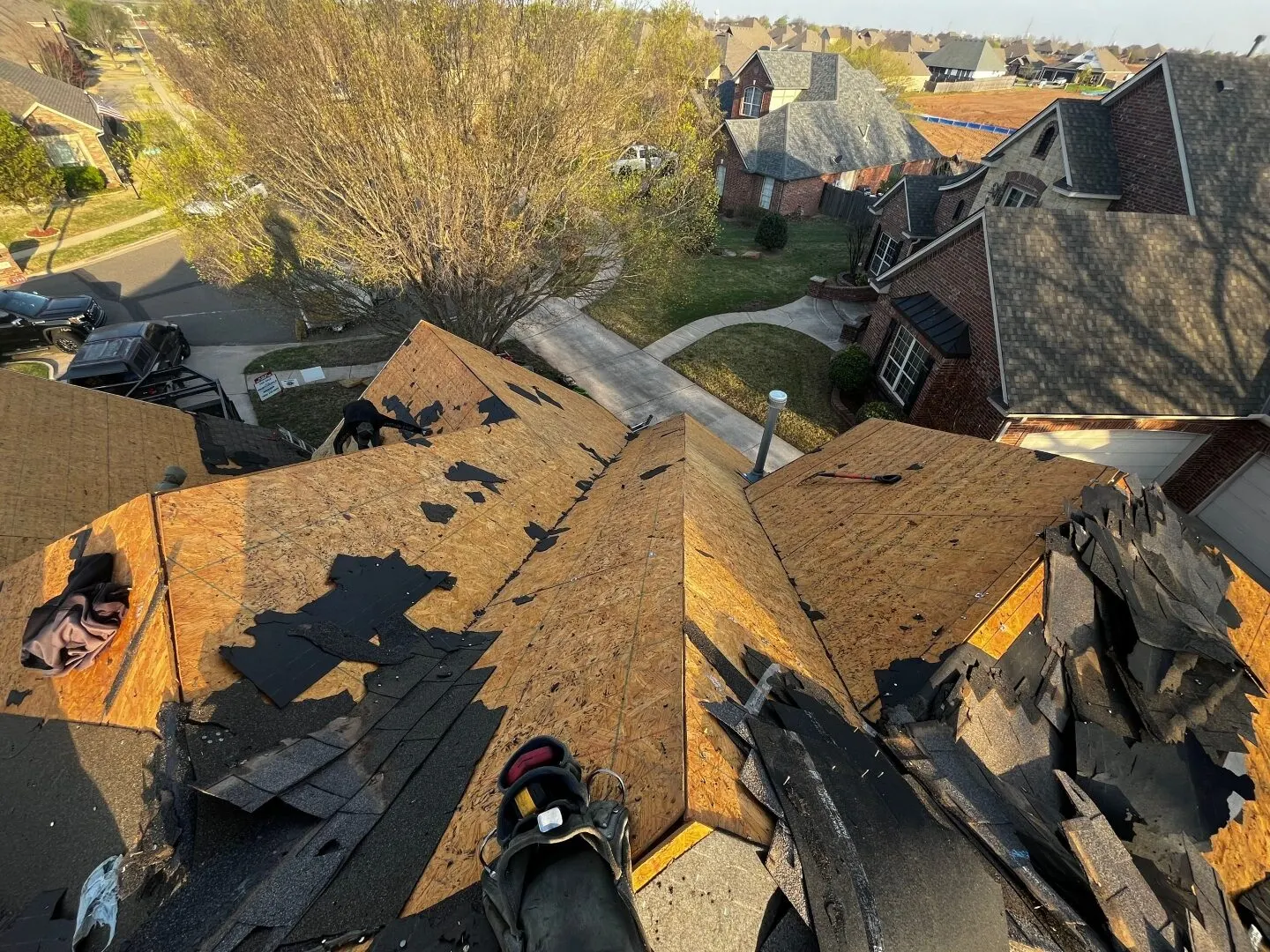 Aerial view of a roof mid tear-off, down to the decking, before a new shingle install