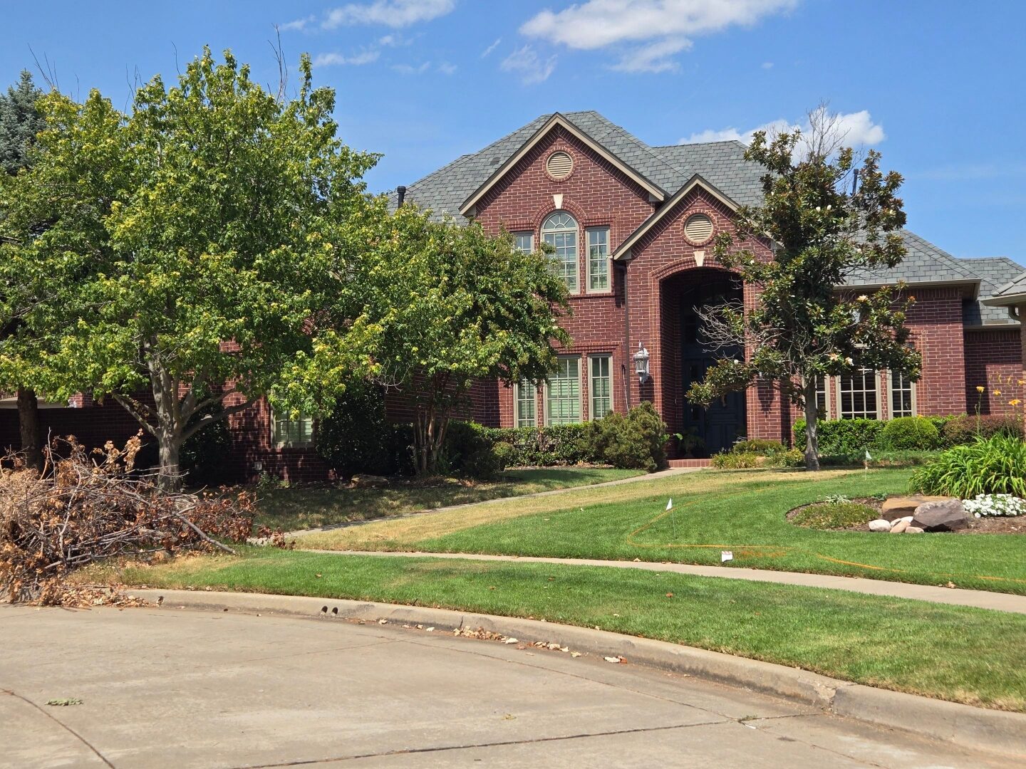Large brick estate home in Norman, Oklahoma with a freshly restored roof, serviced by B & R Restoration